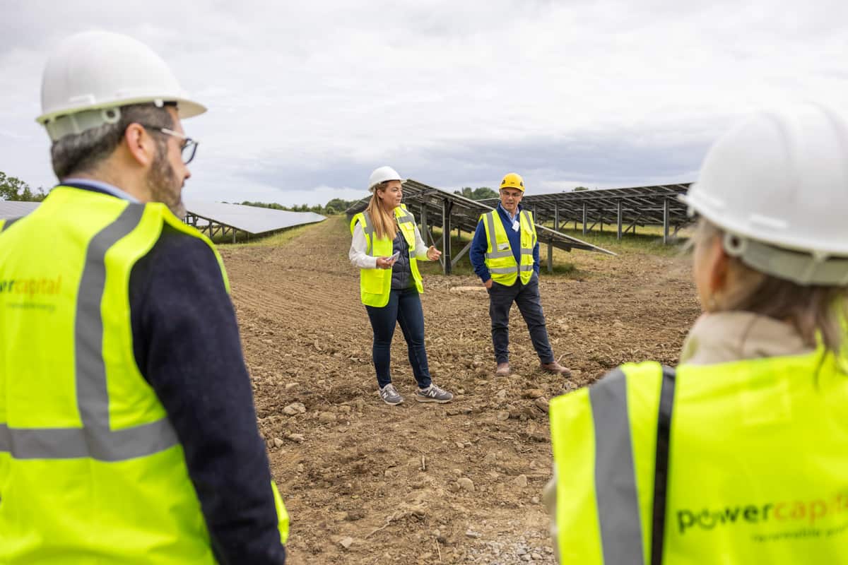 People in high vis and hard hats at solar farm development.