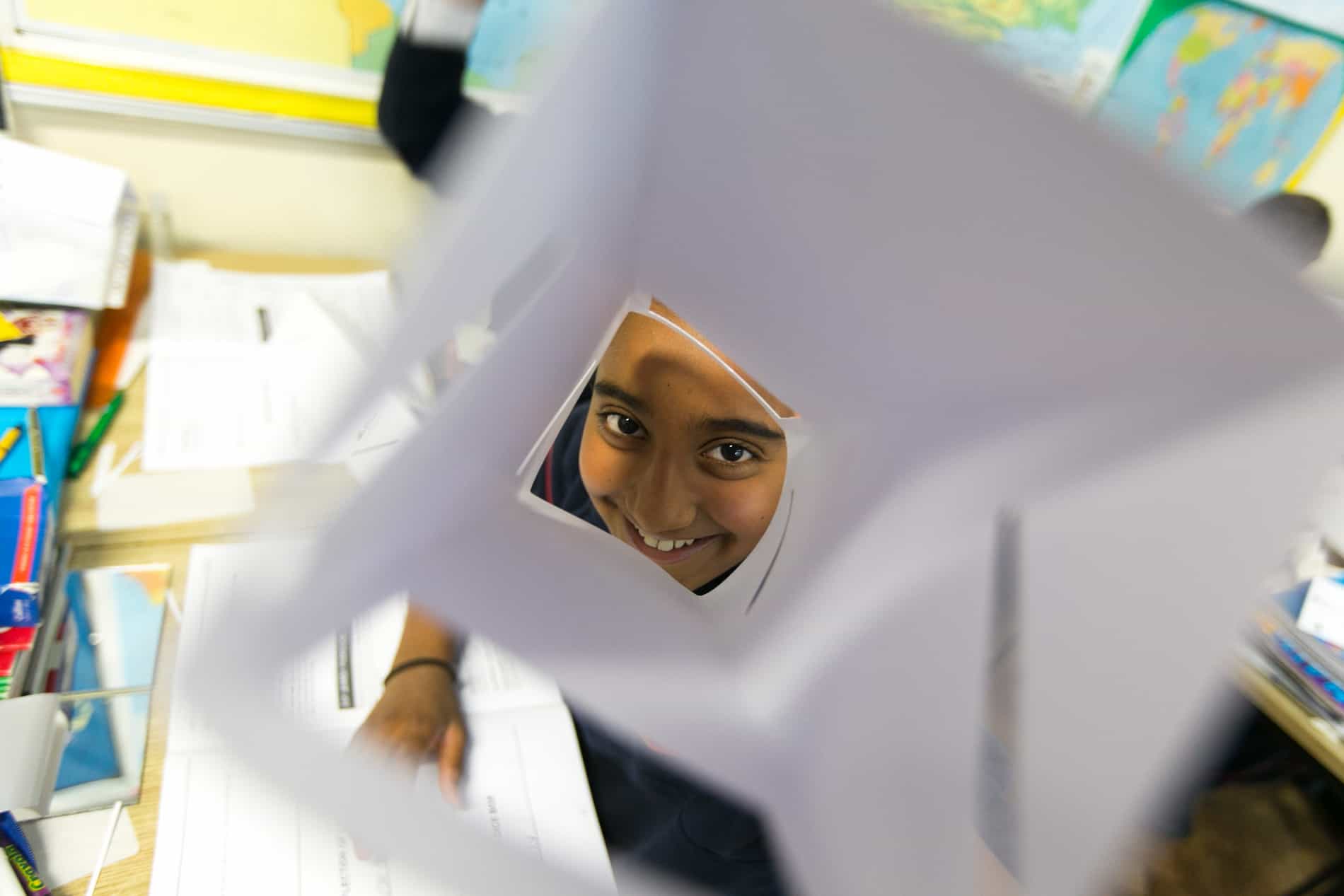 Person peeking and smiling through solar equipment.